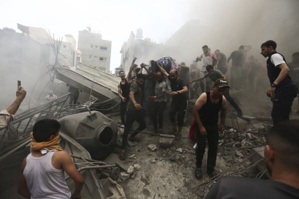 FILE - Palestinians remove a dead body from the rubble of a building after an Israeli airstrike Jebaliya refugee camp, Gaza Strip, Monday, Oct. 9, 2023. As Israeli warplanes pummel Gaza to avenge the Hamas attack, Palestinians say the military has largely unleashed its fury on civilians. (AP Photo/Ramez Mahmoud, File)